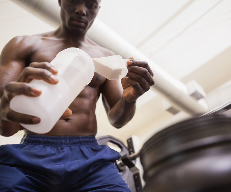 Bodybuilder making protein shake to eat during workout